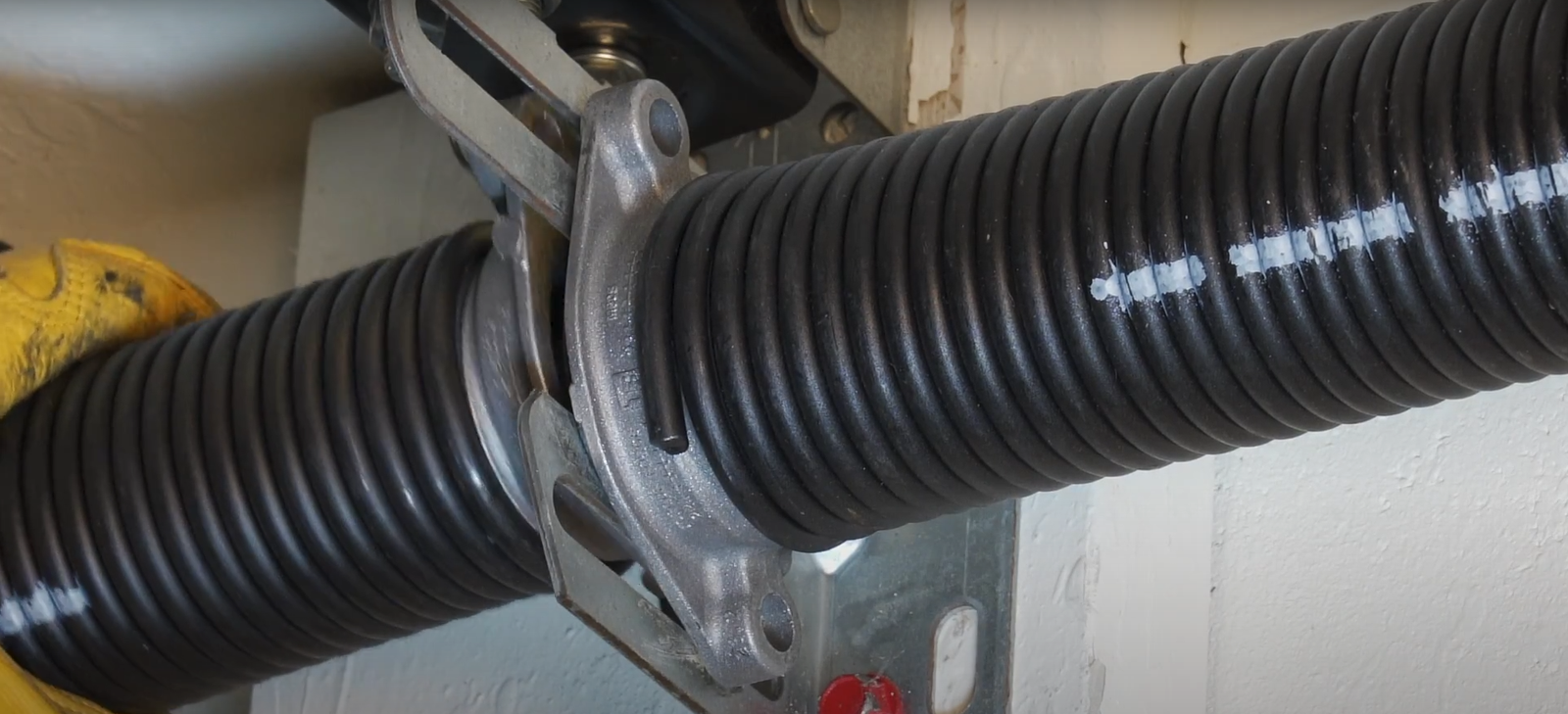 Garage door technician inspecting parts for Garage Door Spring Repair and system safety upgrade