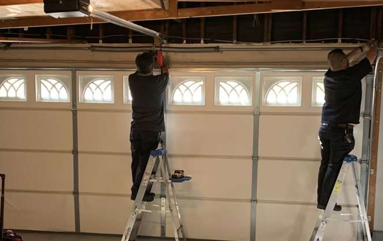 Technician performing garage door repair in Myakka City with tools and equipment